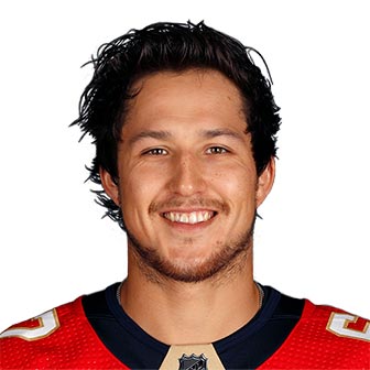 A smiling man wears a Florida Panthers jersey.