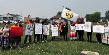 A group of people holding signs demonstrating against Bill 5.