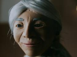 Claymation character is an old woman with grey hair pulled back into a bun behind her head.