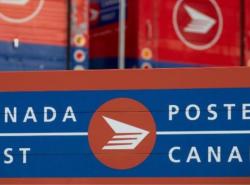 Photo of red mail boxes with the words Canada Post on them and the logo.