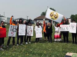 A group of people holding signs demonstrating against Bill 5.